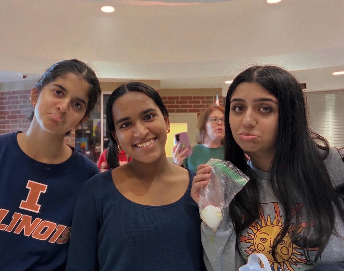 Three students holding up a bagged egg during a hands-on challenge